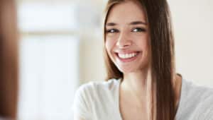 Shy teenage girl smiling after teeth whitening treatment
