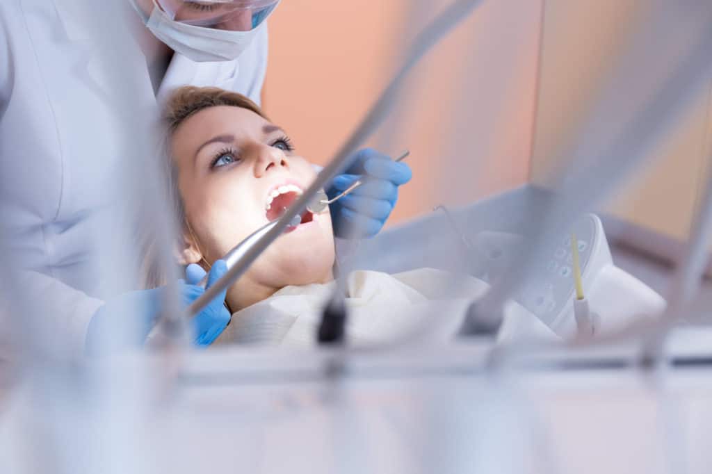 Horizontal view of dentistry examining patient's teeth