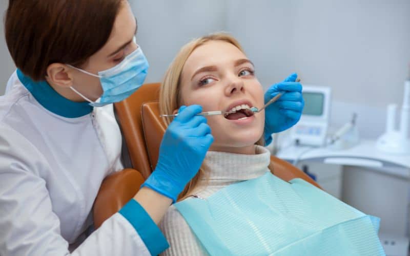 Dentist conducting dental procedure, placing white fillings for tooth restoration