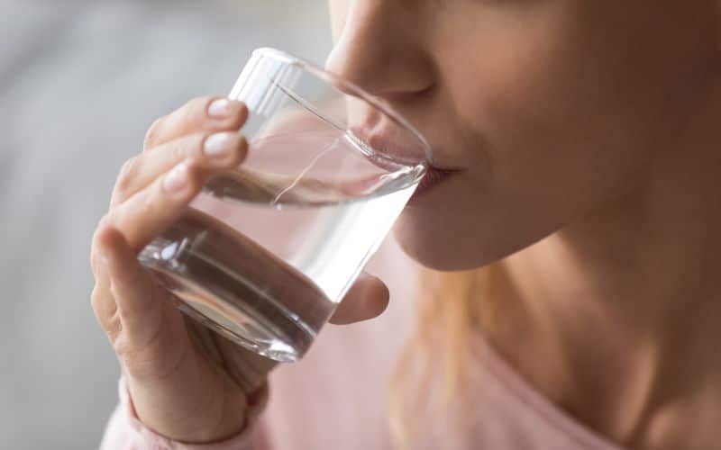 woman holding glass drinks still water preventing dry mouth