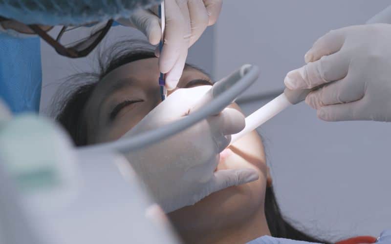 Dentist performing dental procedure with white fillings for tooth restoration