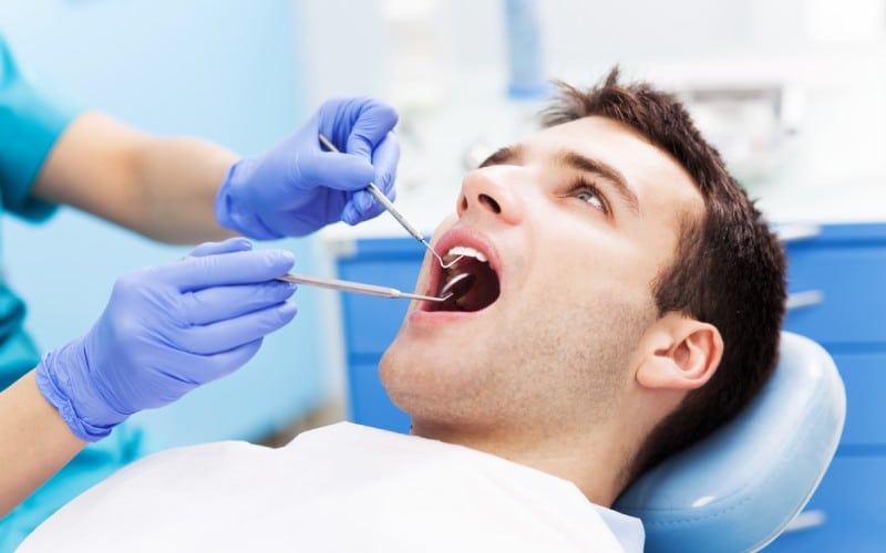 man having teeth examined at dentists