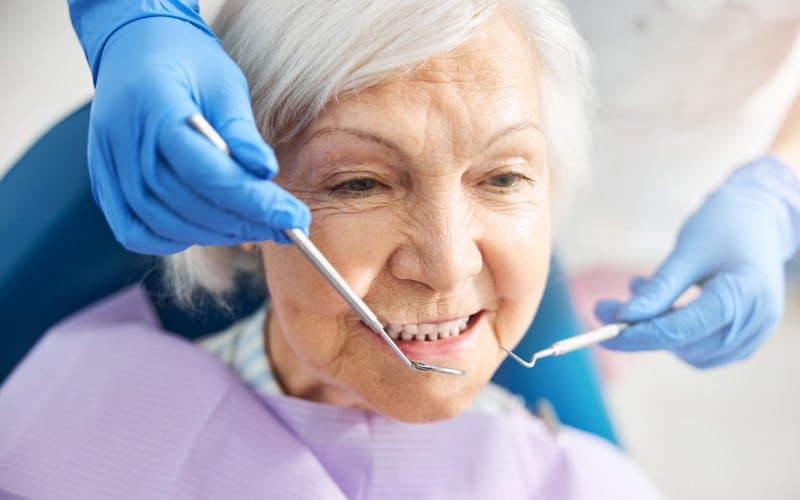 senior-female-receiving dental treatment from a medic