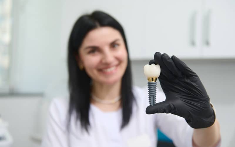 denture dental implant maxillofacial surgery close dentists hand holds model