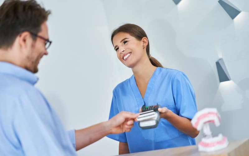 patient paying for dental visit in clinic
