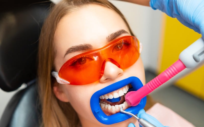 close patient while doing professional teeth cleaning procedure clinic